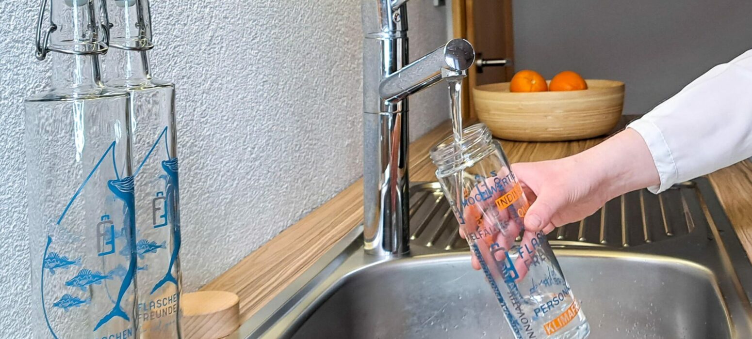 Hochwertige Glastrinkflasche im Flaschenfreunde-Design wird mit Leitungswasser befüllt