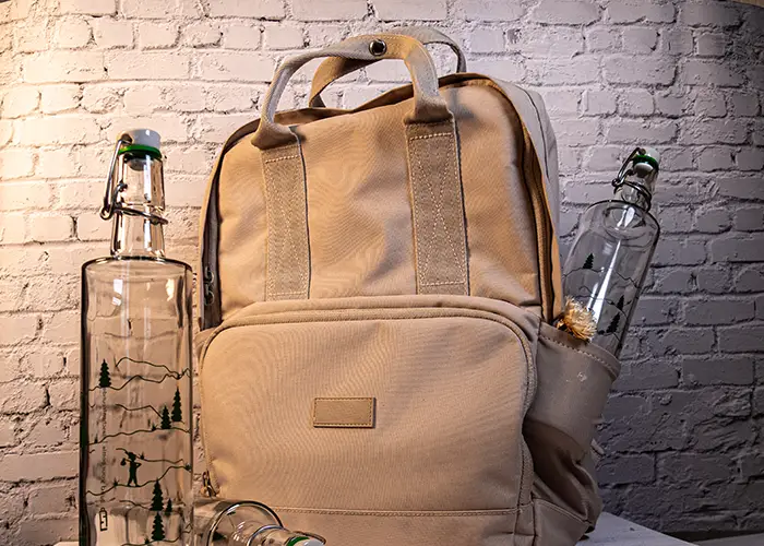 Beigefarbener Rucksack mit 2 Flaschen des Modells "KlareKante"