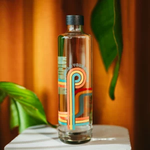Bund bedruckte Trinkflasche auf einem kleinen Tisch vor orangenem Hintergrund