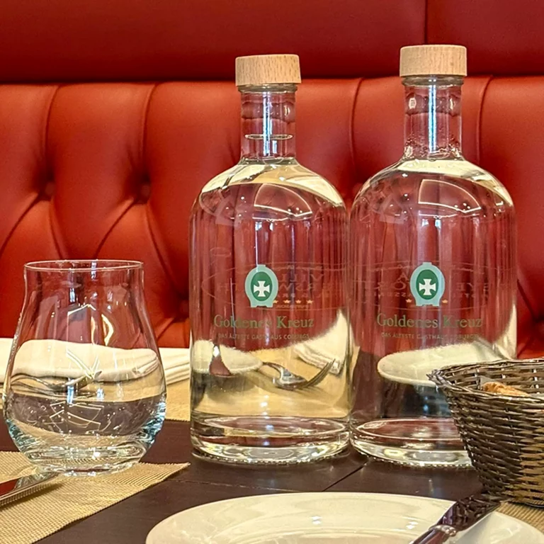 Bedruckte Wasserflaschen aus Glas auf einem gedeckten Tisch in einem Gasthaus