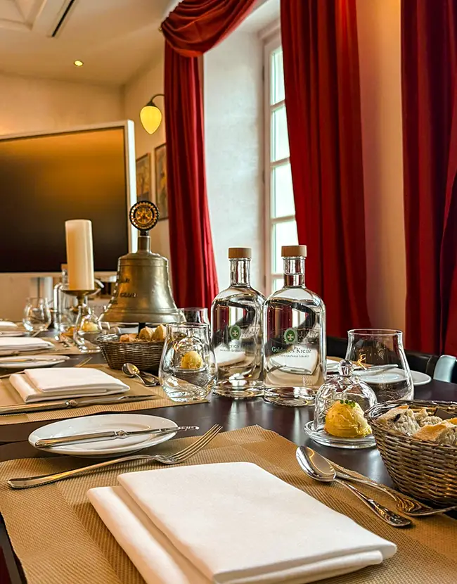 Bedruckte Wasserflaschen aus Glas auf einem gedeckten Tisch in einem Gasthaus