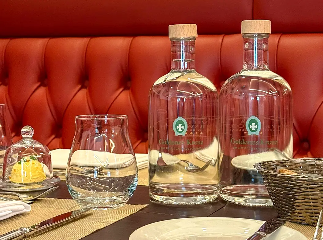Bedruckte Wasserflaschen aus Glas auf einem gedeckten Tisch in einem Gasthaus