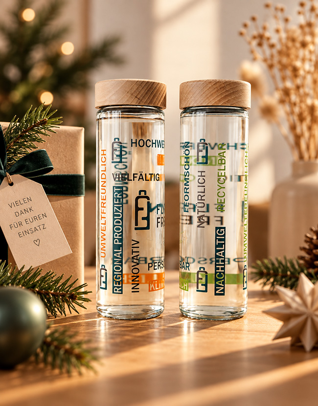 2 bedruckte Glasflaschen als Mitarbeitergeschenk in einem weihnachtlichen Setting
